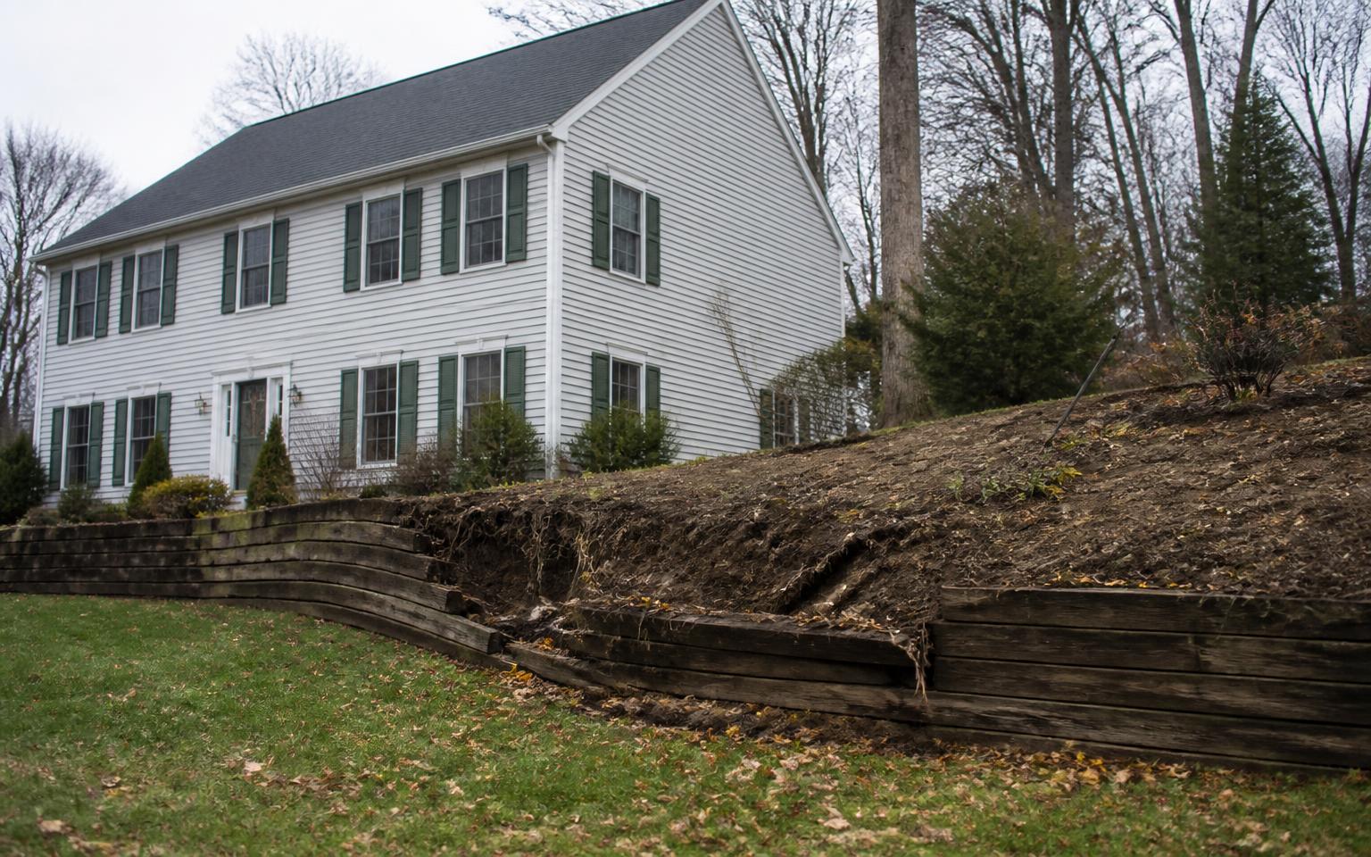 Eroding slope and failing timber edge before retaining wall construction
